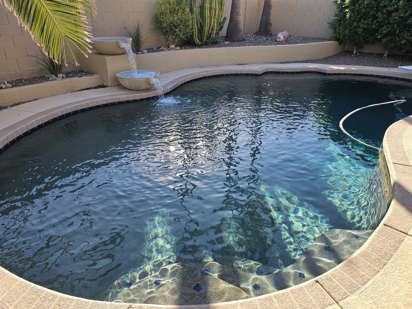 Pristine sparkling backyard pool receiving routine weekly pool service and maintenance in Goodyear, AZ